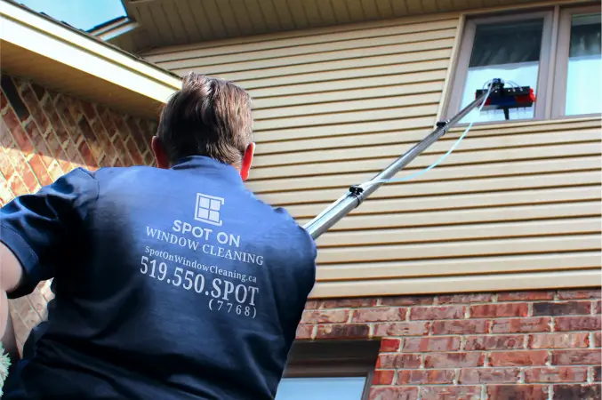 Spot On cleaning the top window of a residential house
